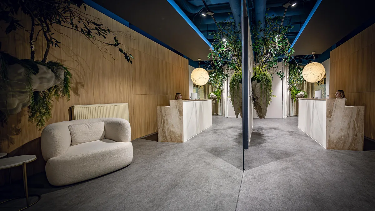 Recepcia kliniky Aezoku Longevity Clinic v Bratislave — drevené obklady, zeleň a svetelné objekty